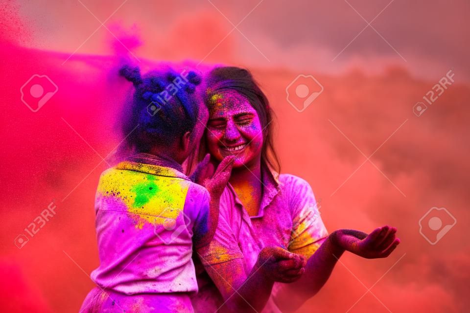 Mutter und Tochter werden auf die Natur der Farben gespielt. zwei spielen mit der farbe beim holi-festival