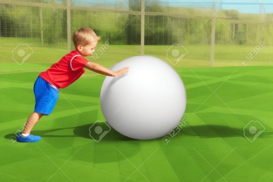 Niño empujando una gran bola pesada