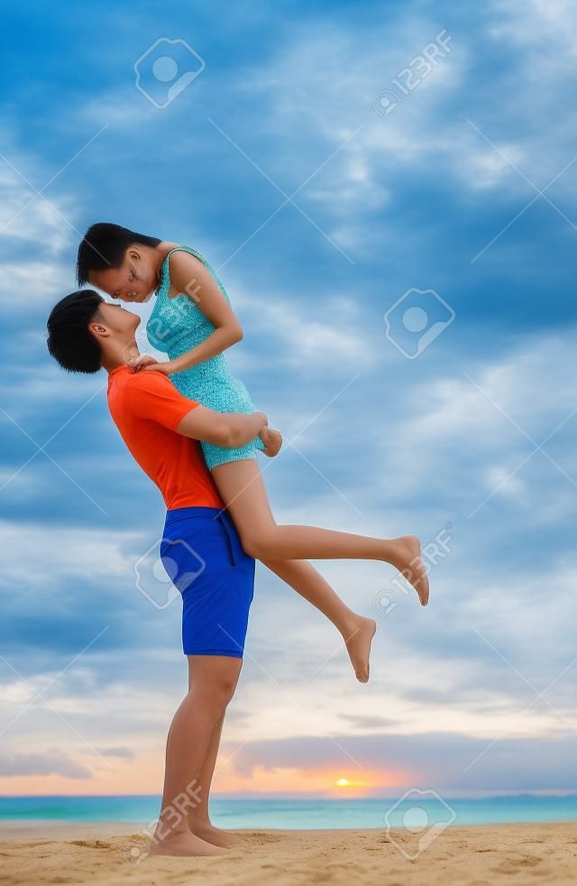 Casal asiático corre togather na praia entre lua de mel no resort na ilha de Phuket, Tailândia, verão, praia, férias, viagens, família e conceito de valentim