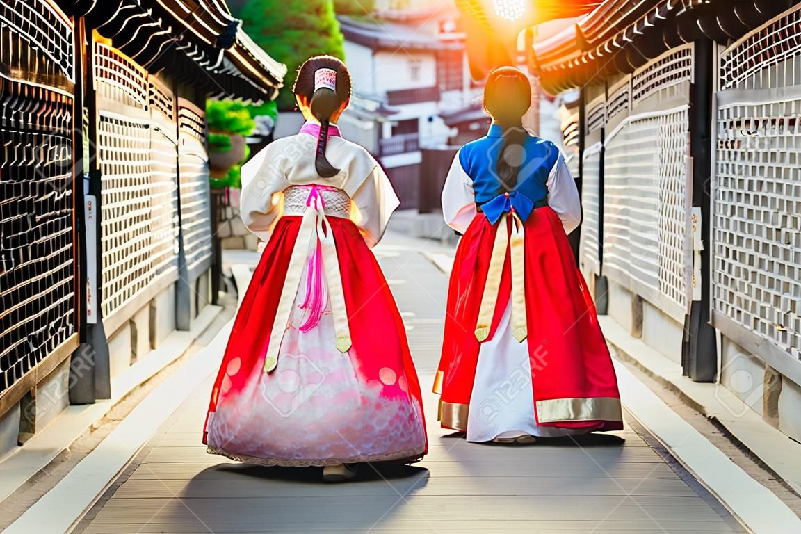 Корейская дама в ханбоке или Корее садится и гуляет в древнем городе в Сеуле, городе Сеул, Южная Корея.