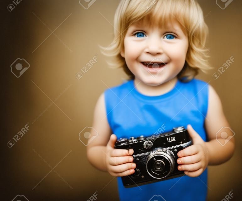 带着旧相机的小男孩