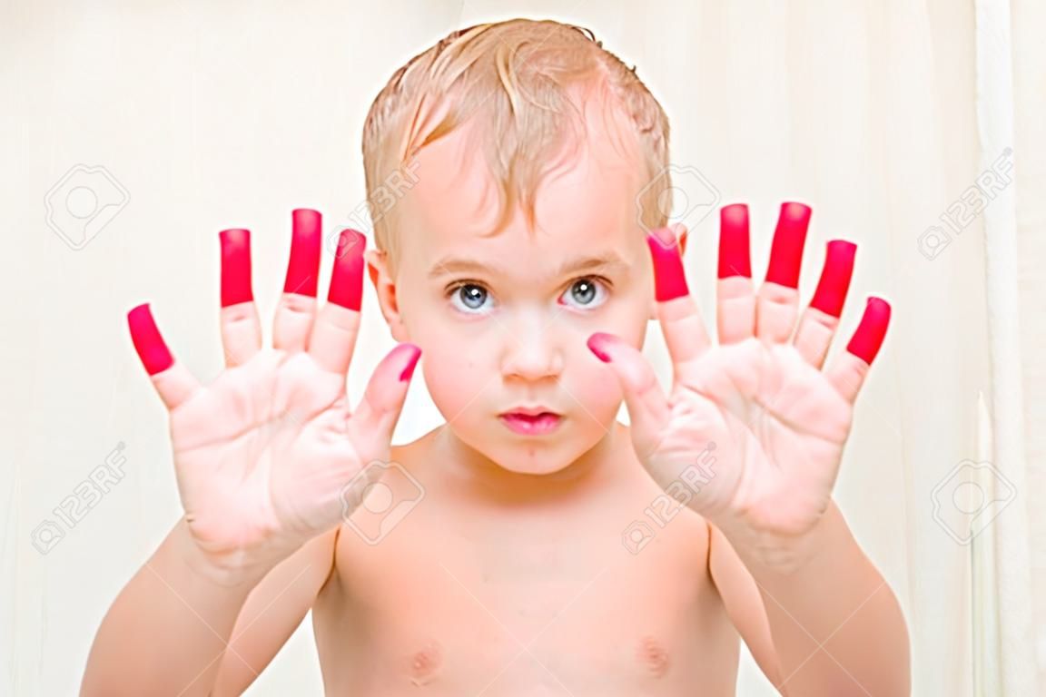 hermoso niño rubio mostrando sus manos en el baño