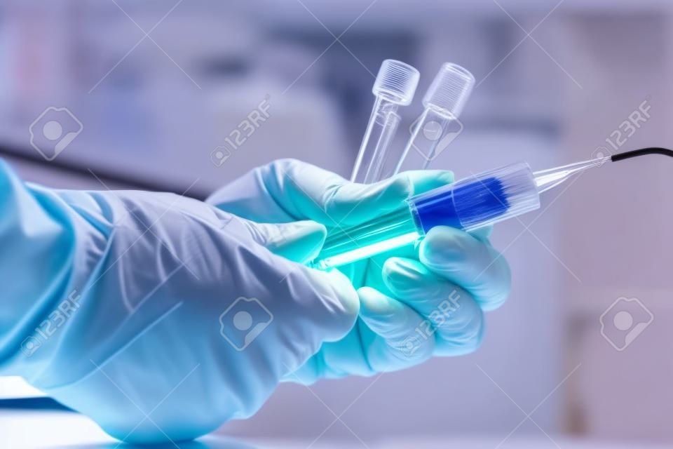 hands of a doctor taking samples of blood tubes for analysis / lab technician drawing blood samples using a tube holder in the clinical laboratory