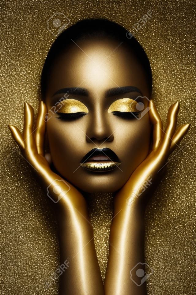 Beauty woman painted in black skin color body art, gold chain in his hands and around his neck. Gold makeup lips eyelids, fingertips nails in gold color paint. professional makeup