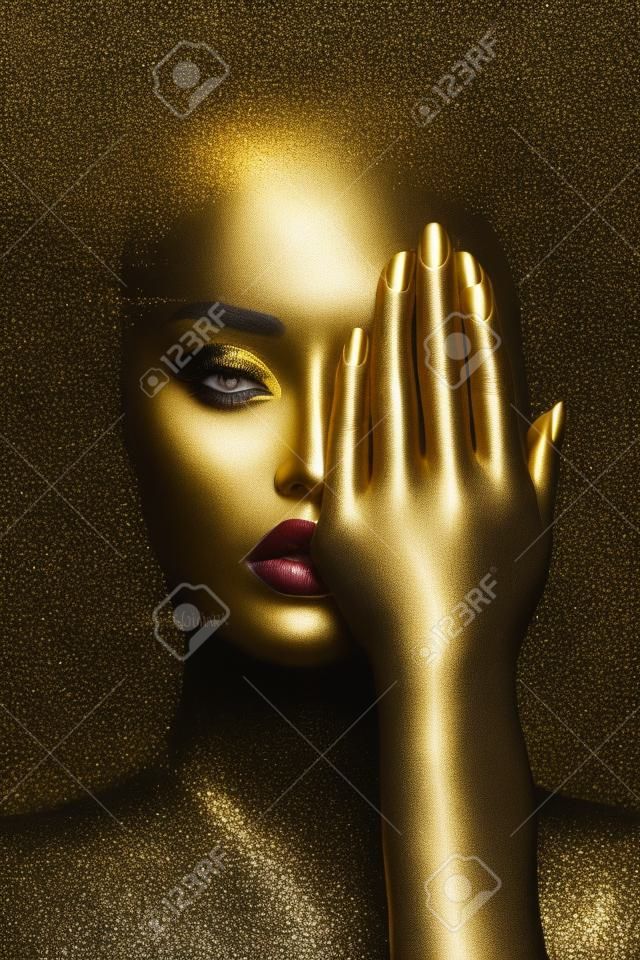 Piękna kobieta malowana w sztuce ciała w kolorze czarnej skóry, złoty makijaż ust, powieki, paznokcie opuszków palców w złotej farbie. profesjonalny złoty makijaż