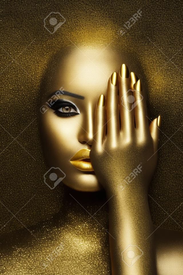 Donna di bellezza dipinta in body art color pelle nera, palpebre labbra trucco oro, unghie della punta delle dita in vernice color oro. trucco professionale d'oro