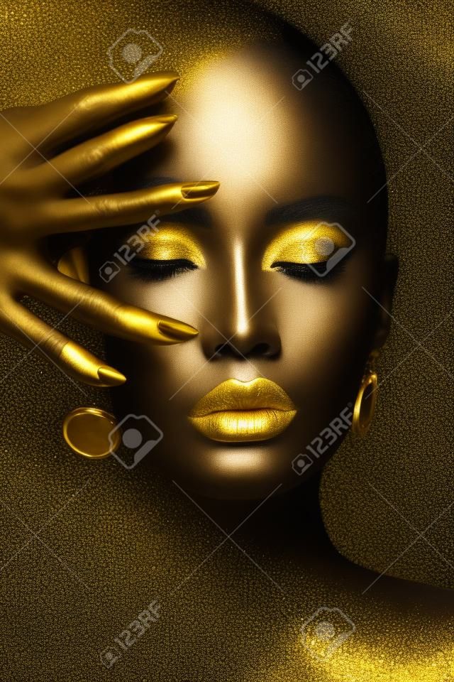 Schönheit Frau schwarze Hautfarbe Körperkunst, goldene Make-up Lippen Augenlider, Fingerspitzen Nägel in goldfarbener Farbe. Professionelles Gold-Make-up