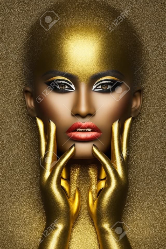 Piękna kobieta czarny kolor skóry tatuaże do ciała, złoty makijaż usta powieki, paznokcie na opuszkach palców w kolorze złotym farby. profesjonalny złoty makijaż