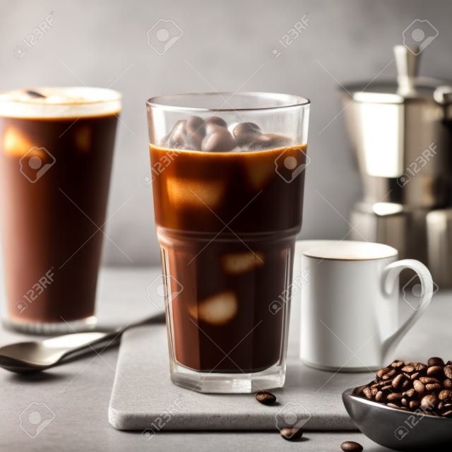 Лед кофе в высокий стакан и кофе в зернах на сером фоне каменных
