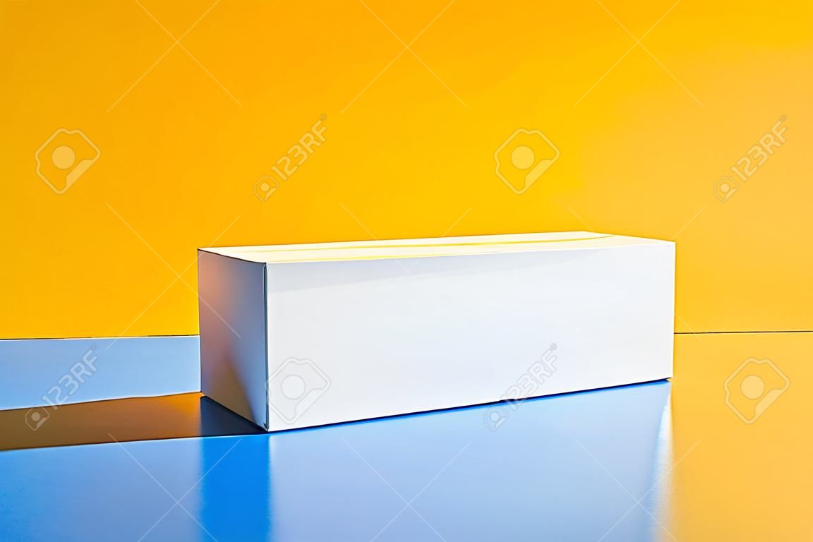 Boîte blanche. Maquette de boîte de médicaments. Maquette. Copiez l'espace. Fond isométrique de minimalisme créatif jaune et bleu. Lumière forte. Ombres