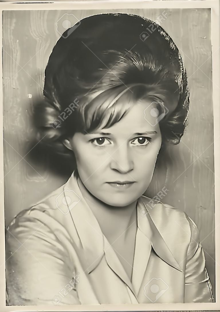 old scratched  black and white portrait old photograph of a woman from the 60s