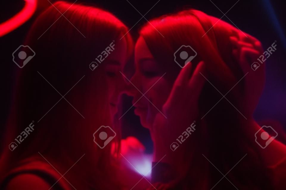 Two girls kisses like lesbians in a night club