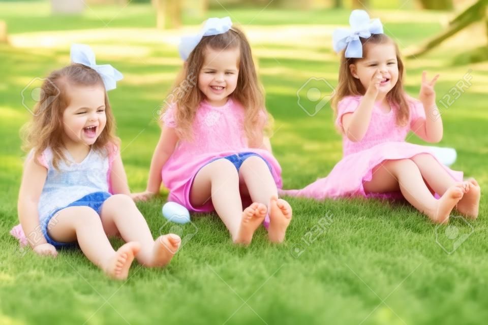 Barfuß kleinen Schwestern ihren Zehen wackeln und Spaß in einem Park