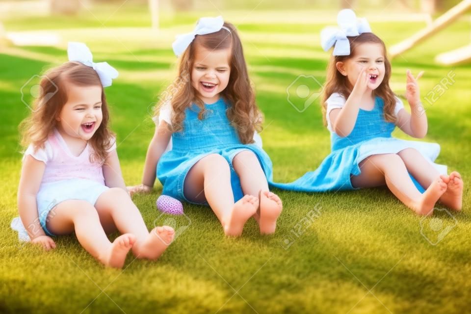 Barefoot kleine zussen wiebelen hun tenen en plezier hebben in een park