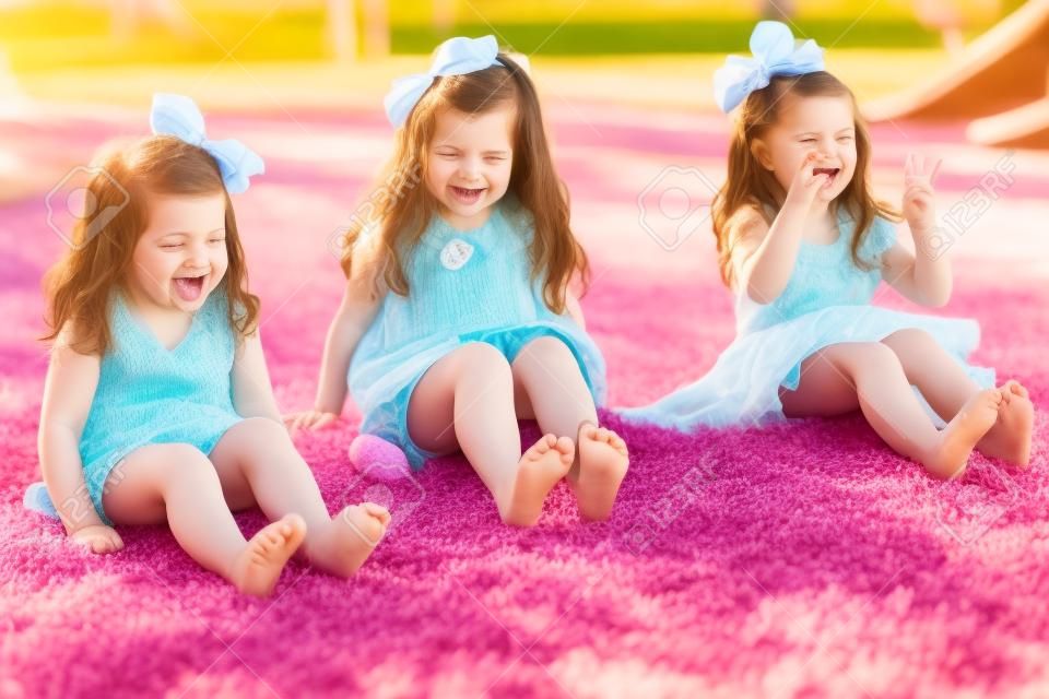 Barfuß kleinen Schwestern ihren Zehen wackeln und Spaß in einem Park