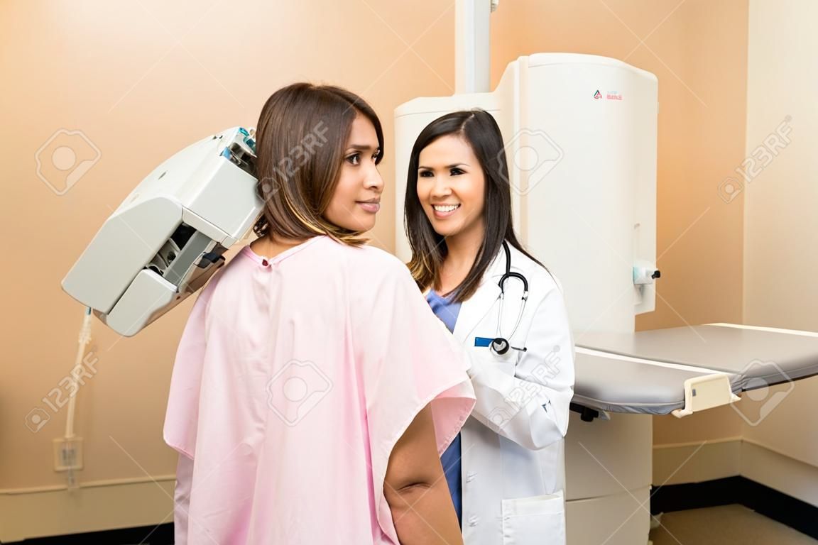 Portret van een mooie Latijns-Amerikaanse patiënt en haar arts in het midden van een mammografie in een ziekenhuis