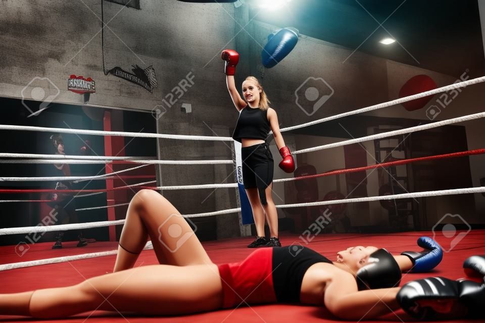 好看的年輕女子，在拳擊館的一場拳擊比賽中將她擊倒後，看著她擊敗了對手