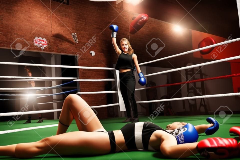 好看的年輕女子，在拳擊館的一場拳擊比賽中將她擊倒後，看著她擊敗了對手