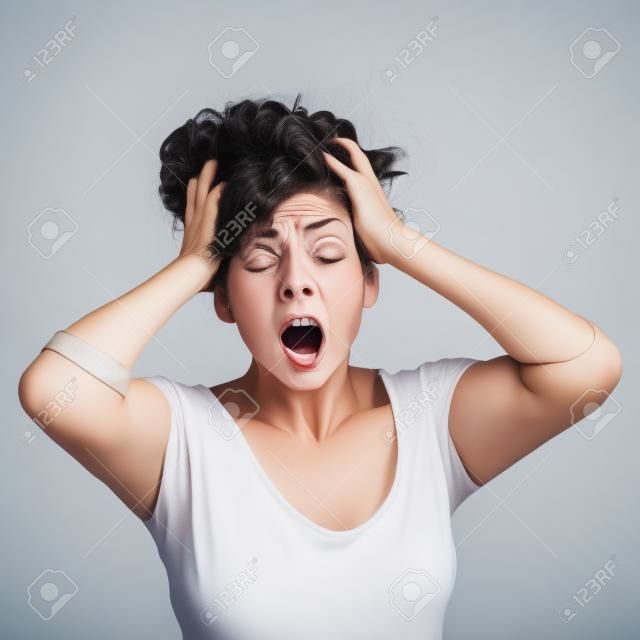 Scared Frau mit ihren Händen auf dem Kopf und geöffnetem Mund auf einem weißen Hintergrund isoliert