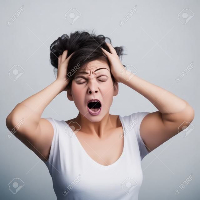 Scared Frau mit ihren Händen auf dem Kopf und geöffnetem Mund auf einem weißen Hintergrund isoliert