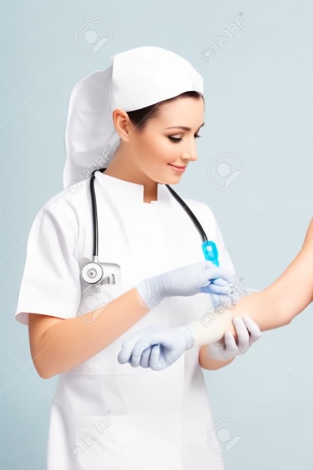 Hermosa enfermera dar una inyección aislada en un fondo blanco