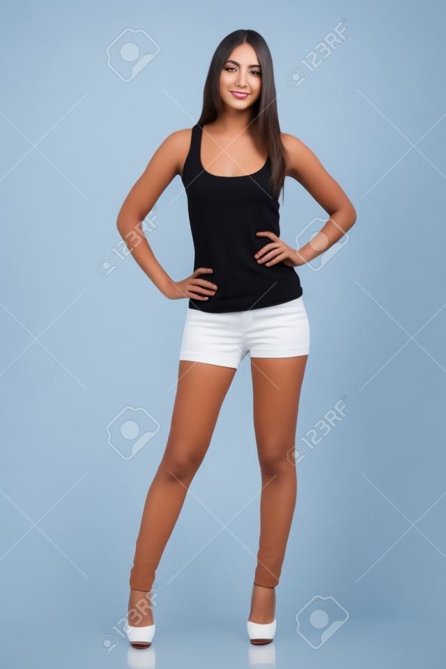 Vista frontale di una bella donna modello in piedi in posa isolato su uno sfondo bianco
