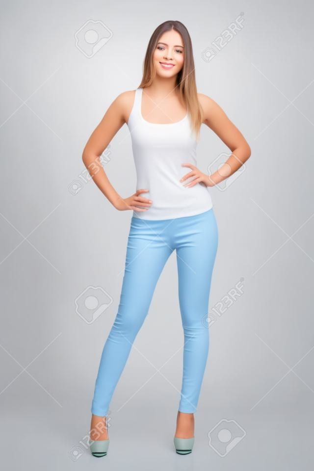 Vista frontal de una bella modelo de mujer de pie posando aislado en un fondo blanco