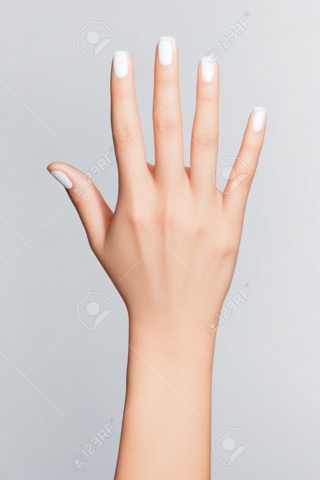 女性は、白い背景に分離されたフランス語マニキュアの手を開いてください。