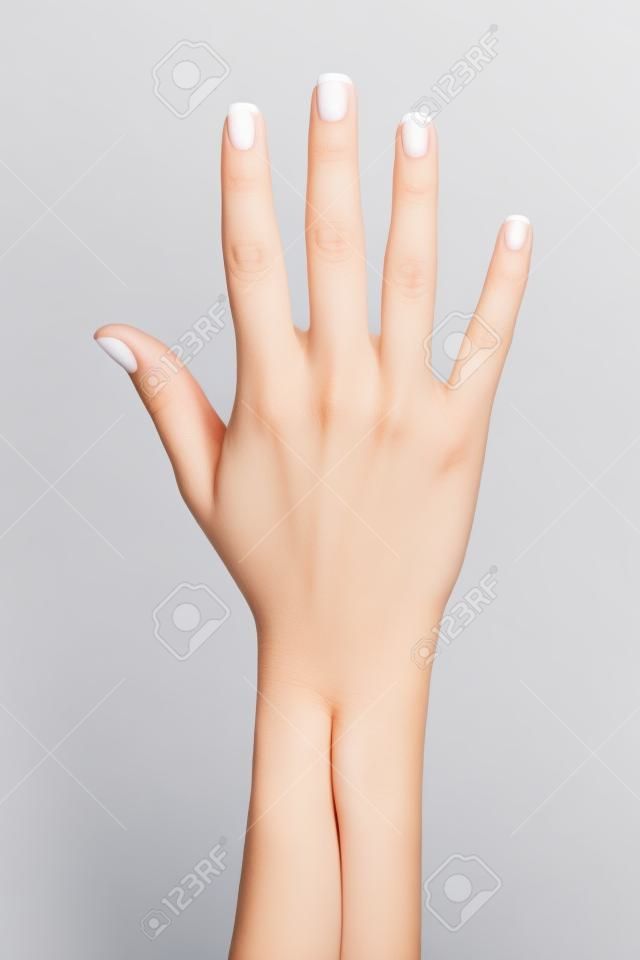 Mão aberta da mulher com manicure francês isolado em um fundo branco