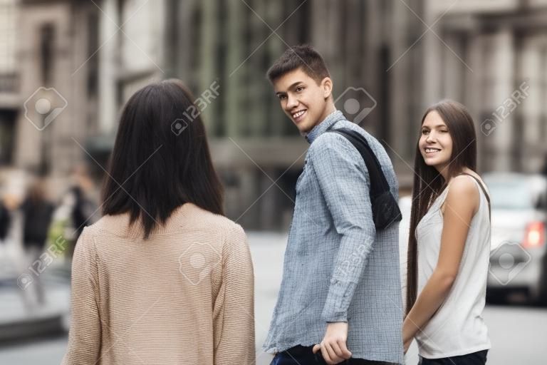 Ontrouwe man lopen met zijn vriendin en kijken verbaasd naar een ander verleidelijk meisje