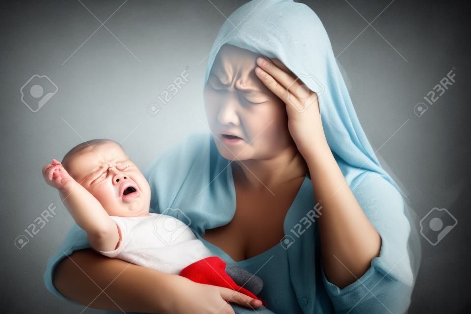 울고있는 그녀의 화난 아기를 들고 절망적 인 어머니