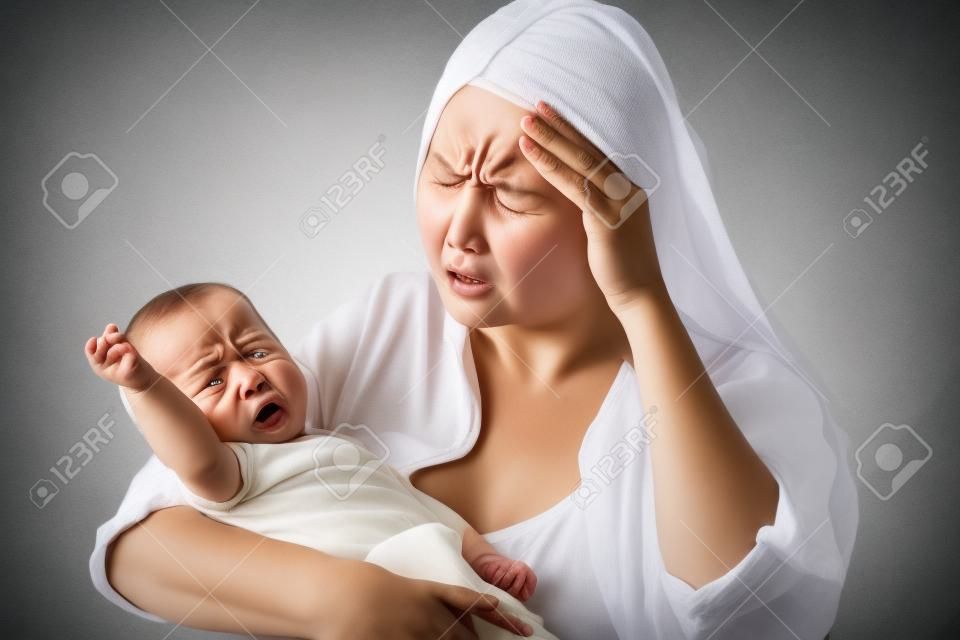 울고있는 그녀의 화난 아기를 들고 절망적 인 어머니