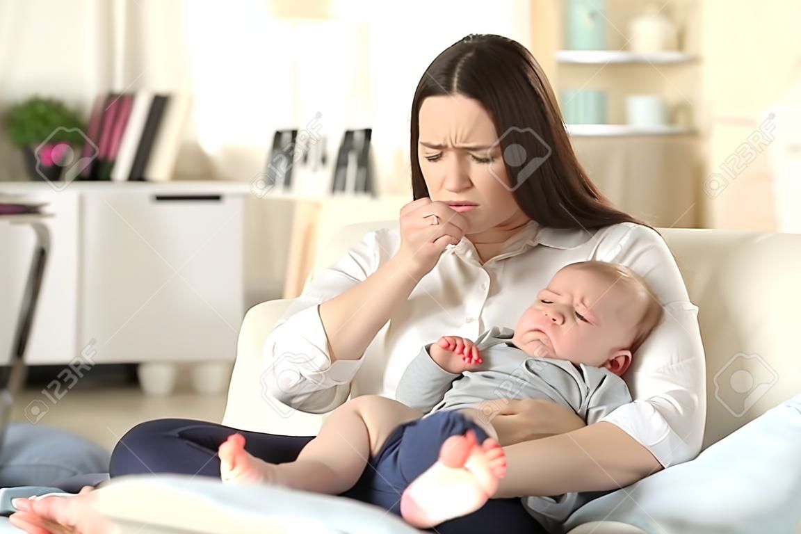 Moeder lijden en baby huilen wanhopig zittend op een bank in de woonkamer thuis