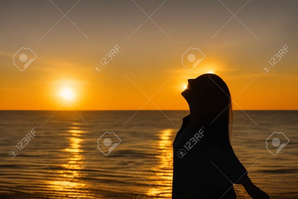 Vista lateral, retrato, de, um, mulher feliz, silhueta, praia, respirando, em, pôr do sol