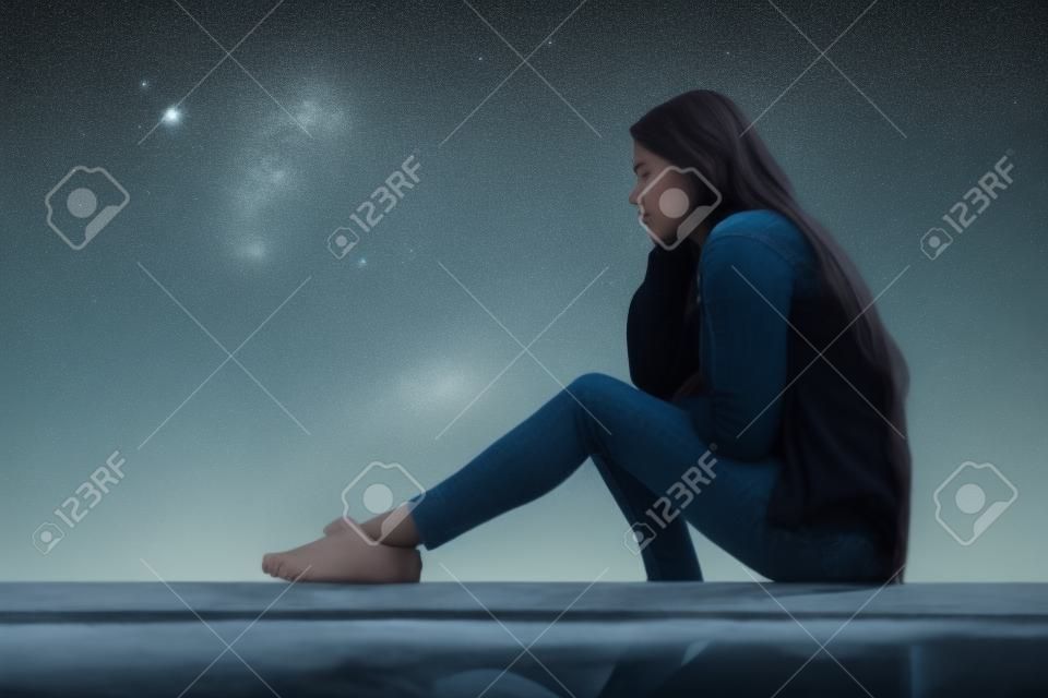 Seitenansicht Porträt eines traurigen Mädchens, das allein wegschaut und draußen sitzt und den Horizont betrachtet