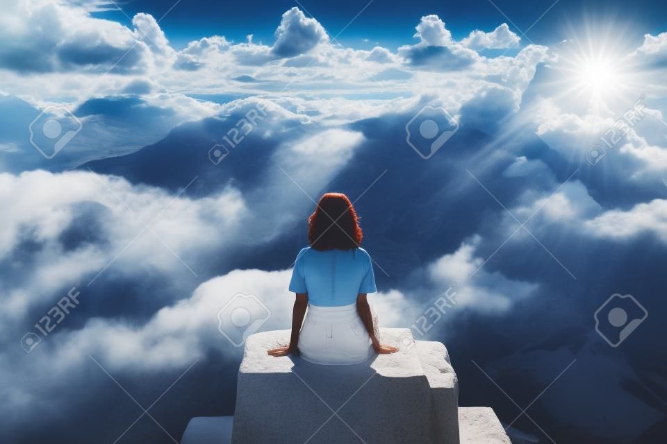 Mujer en la cima de la montaña con un hermoso paisaje de cielo.
