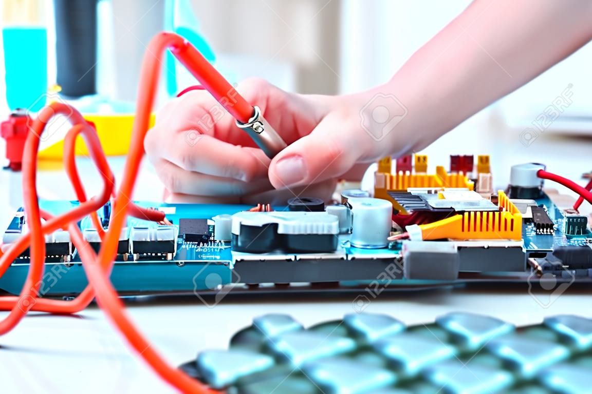Elektronik-Reparatur-Service, die Hände der weiblichen Tech reparing eine elektronische Schaltung