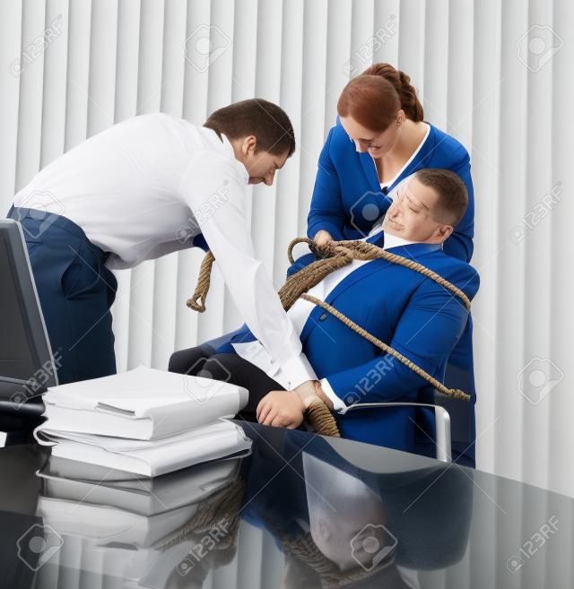 Empregados amarrando o gerente de escritório a sua cadeira com uma corda