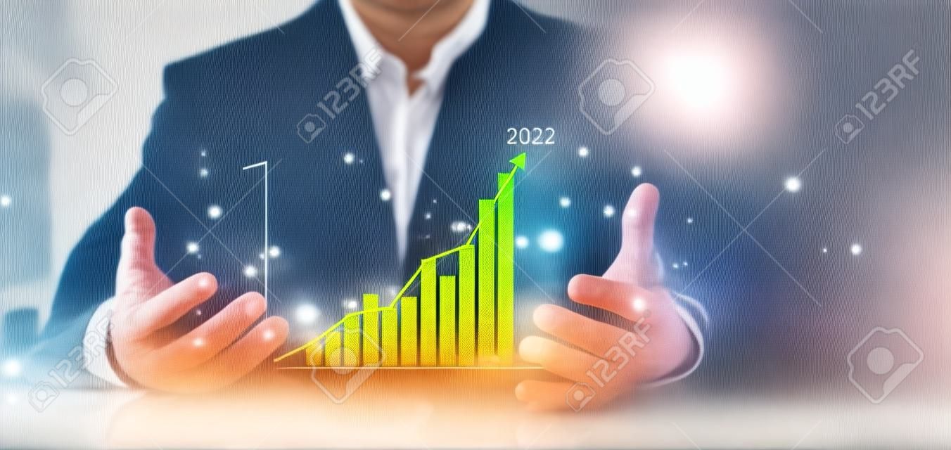 El hombre de negocios muestra un gráfico de barras dorado del mercado de valores que crece hasta el objetivo. concepto de finanzas empresariales. las manos del hombre de negocios muestran un gráfico de éxito, las acciones crecen cada año y establecen metas para 2023