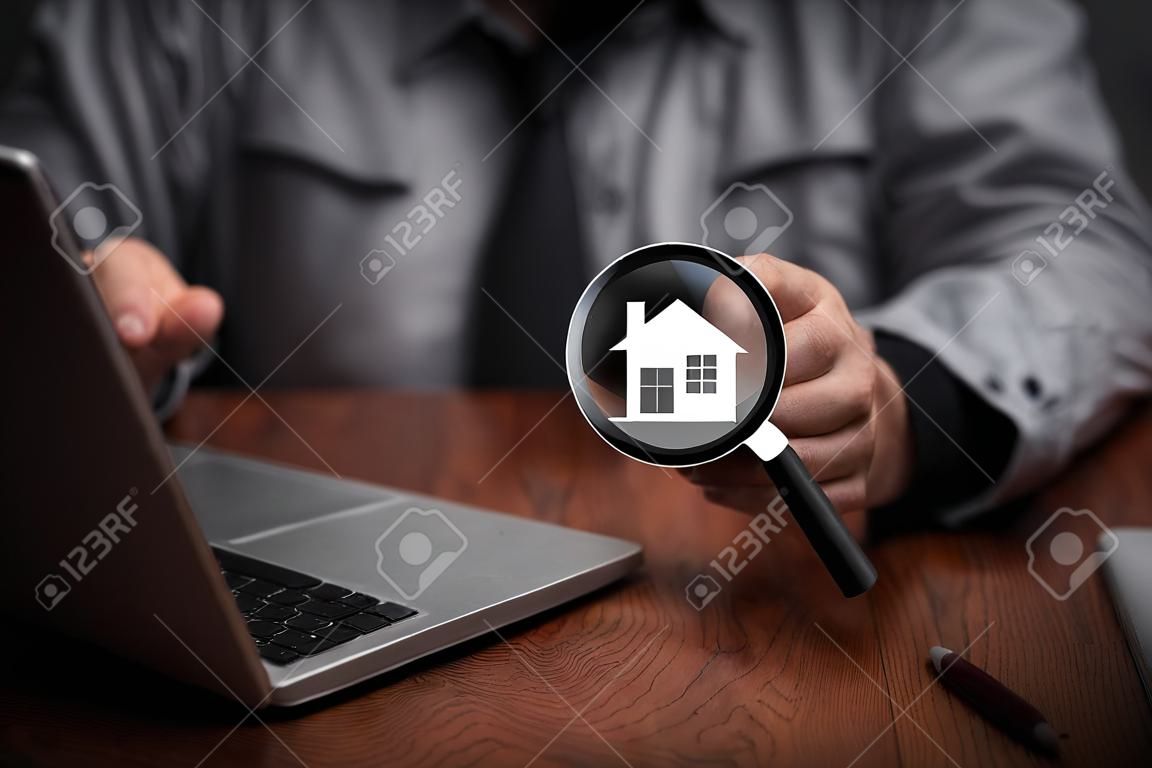 Man hold magnifying glass searching house. real estate agency, property insurance, mortgage loan or new home.