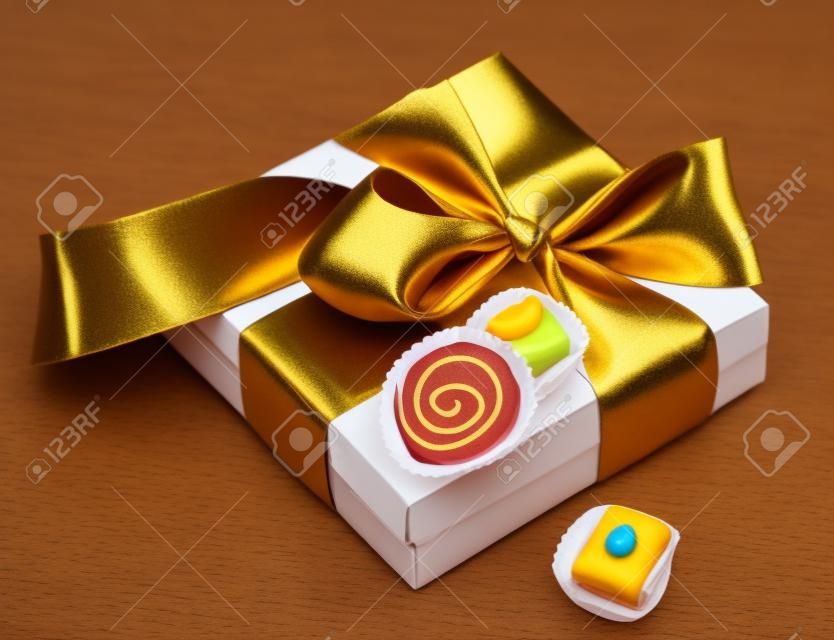 scatola marrone con caramelle e nastro d'oro