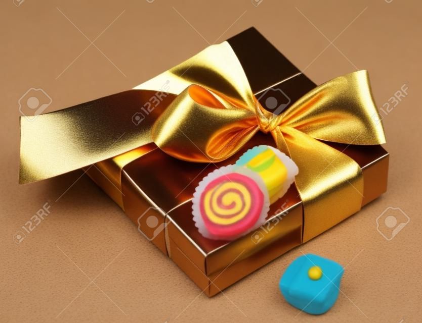 коричневая коробка с конфетами и золотой лентой