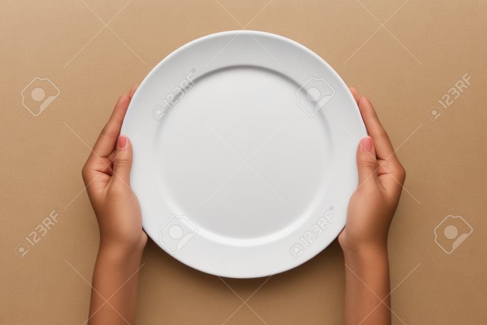 Weiblich (Frau) Zwei Hände halten (Unterstützung) a white dish (Platte) isoliert weißen und Draufsicht.