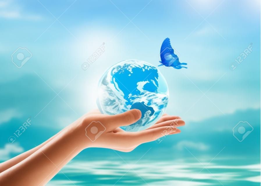 Giornata mondiale dell'oceano, campagna di risparmio idrico, concetto di ecosistemi ecologici sostenibili con terra verde sulle mani della donna su sfondo blu del mare