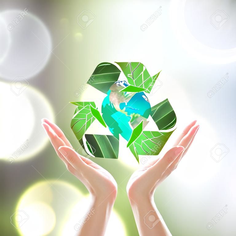 World environment day and ecology concept with woman human hands under green planet with recycle sign.