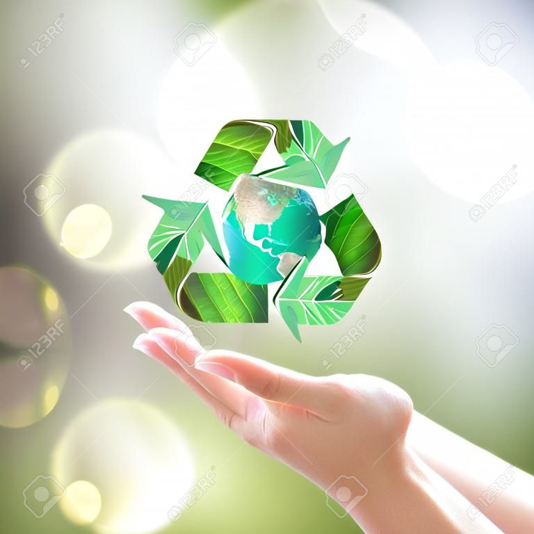 World environment day and ecology concept with woman human hands under green planet with recycle sign.