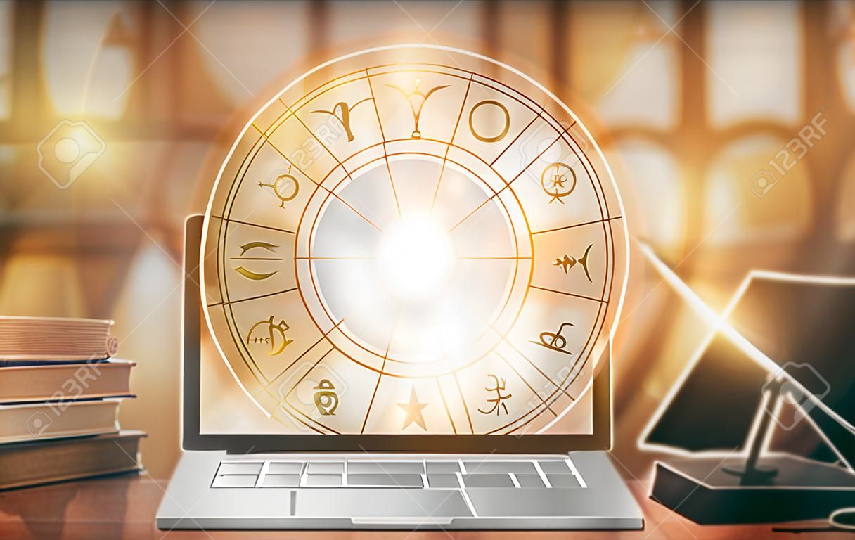 Online horoscope with zodiac sign astrology and constellation study  for foretell and fortune telling education course concept with horoscopic wheel over old book and computer laptop in school library