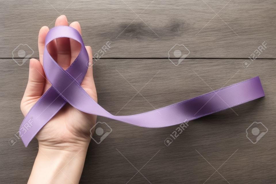 Lavendelband für Krebsbewusstsein (alle Arten) Farbe auf menschliche Hand gealtertes Holz gespritzt