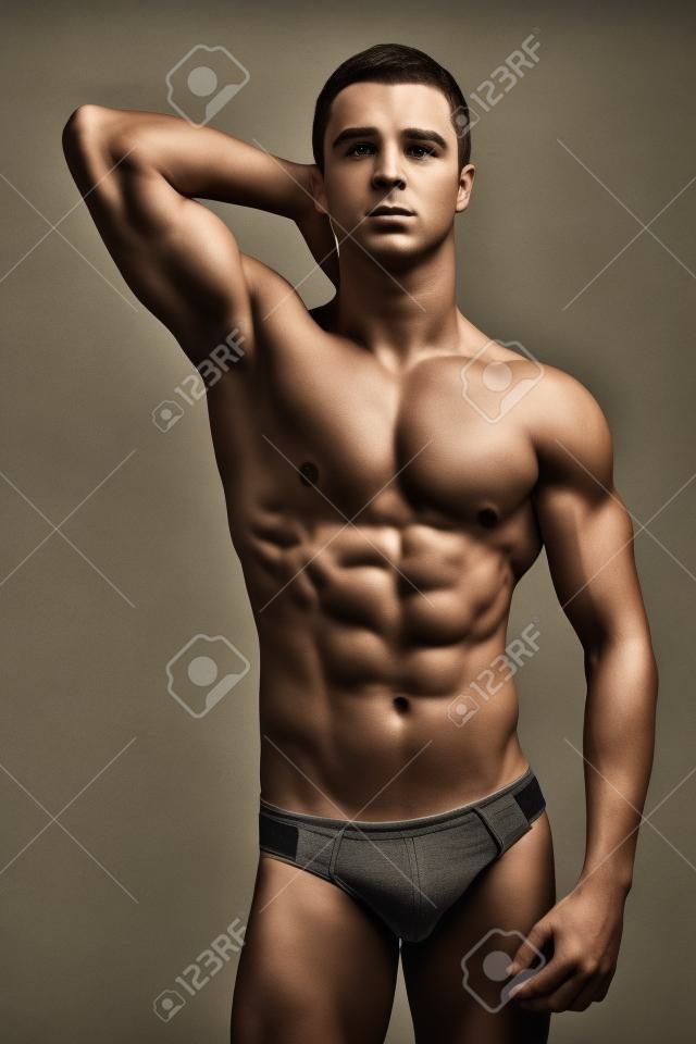 Studio retrato de un hombre joven muscular