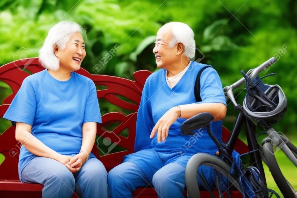 一出手亞洲高級情侶在公園坐在長椅上